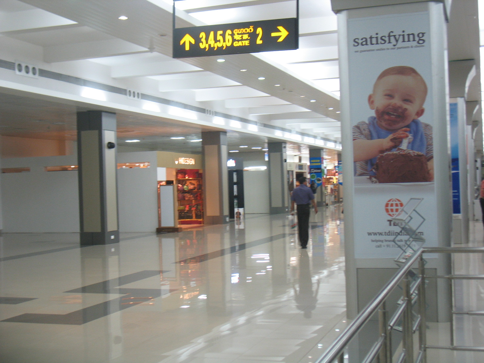 Airport Terminal | Indian Press An airport hallway with signage for gates 3 through 6 illustrates the theme of return migration.