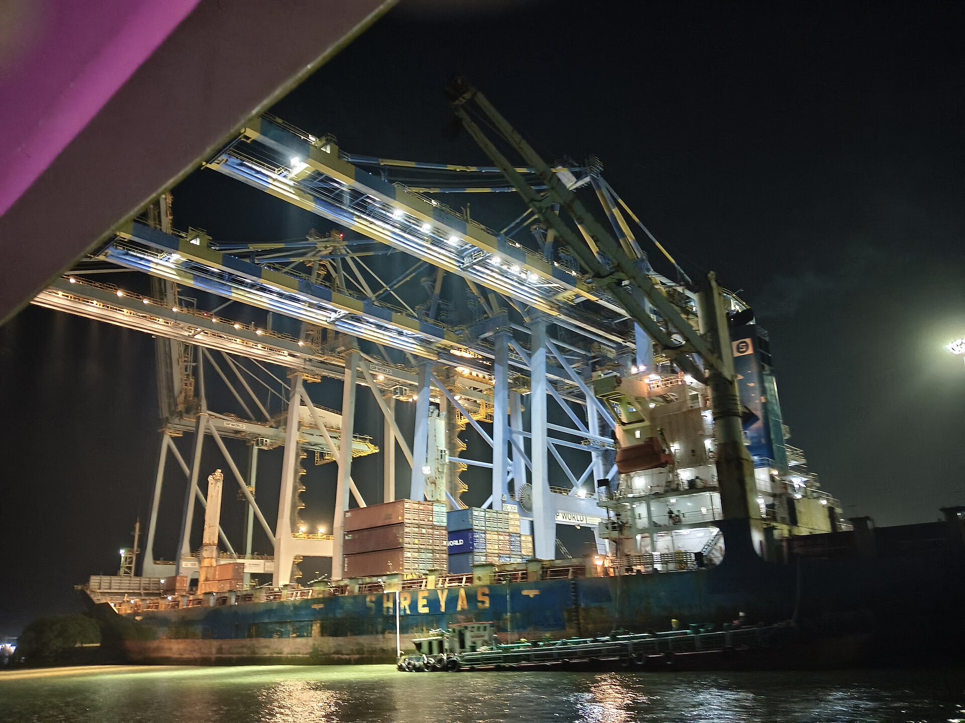 Container Ship | Indian Press A brightly lit port shows a container ship being loaded, illustrating the Gulf trade corridor.