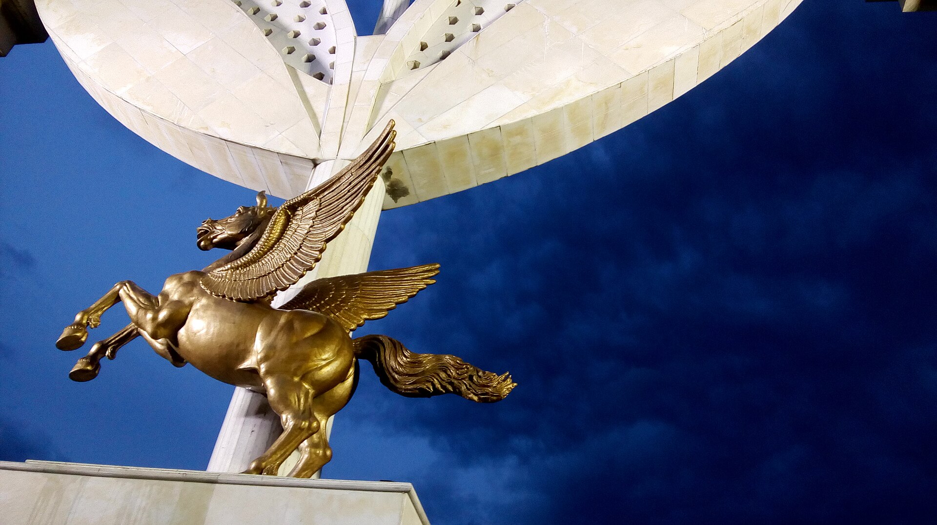 Pegasus Statue | Indian Press A golden Pegasus statue is displayed beneath an architectural structure, relating to the Dravidian Movement.
