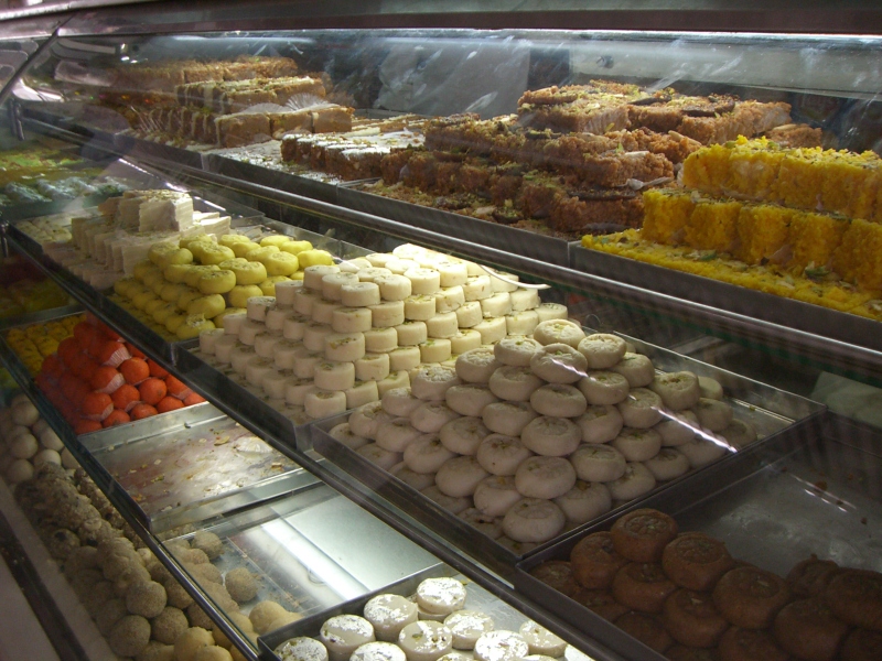 Indian Sweets | Indian Press A display case filled with colorful Indian sweets and desserts, perfect for a festival celebration.