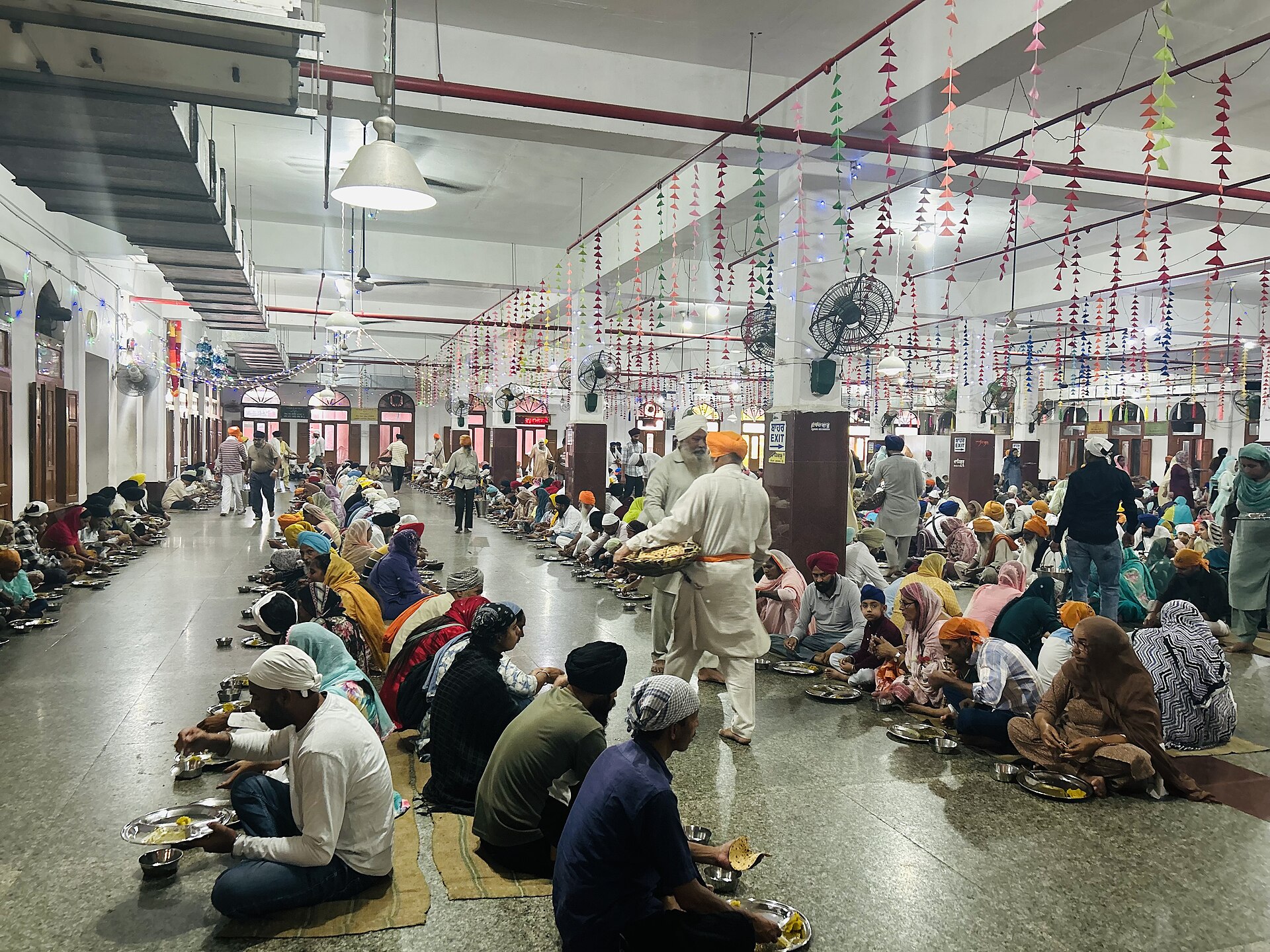 Golden Temple | Indian Press People share a communal meal at a Gurdwara, demonstrating the Sikh tradition of Langar and community spirit.