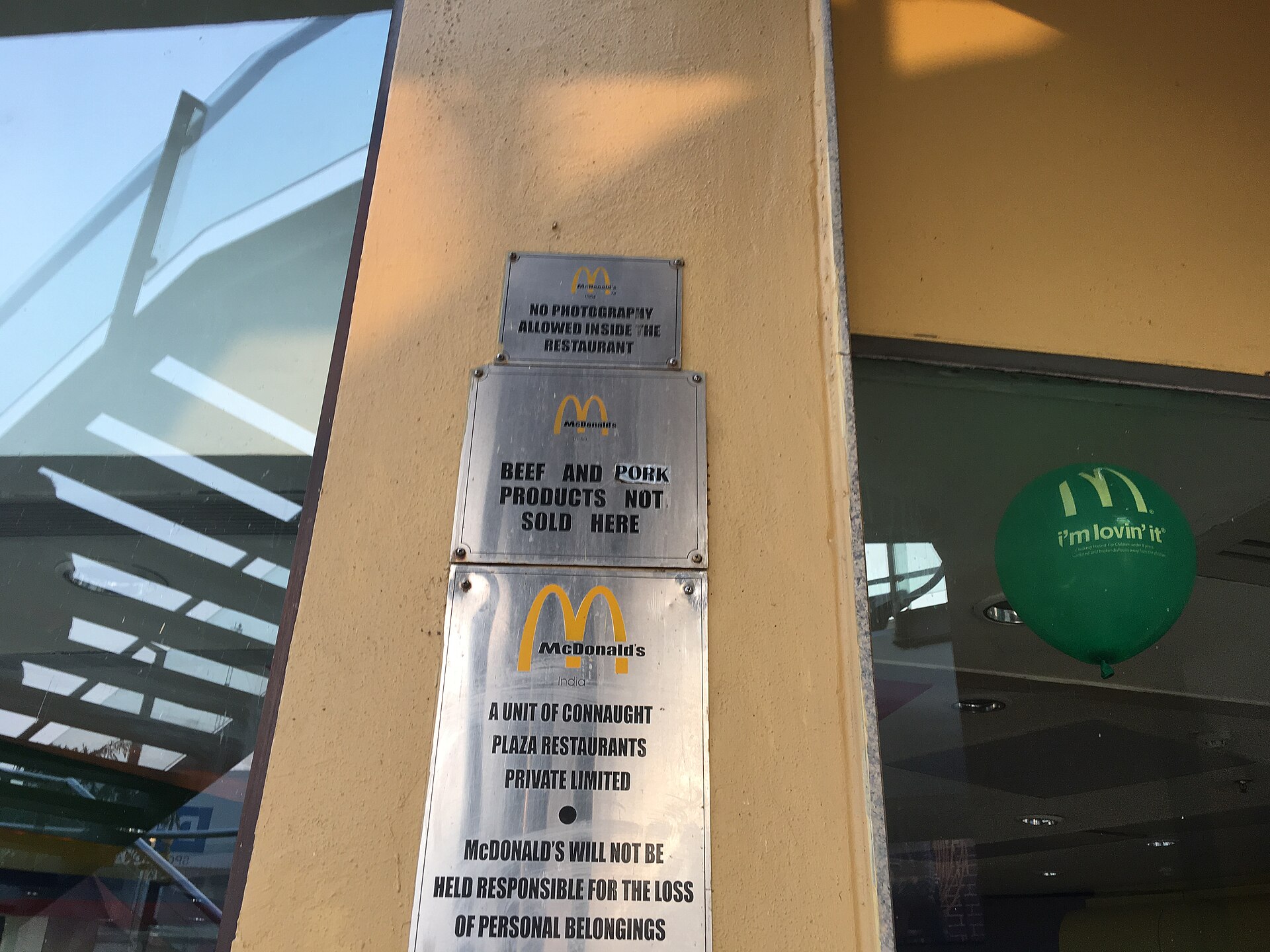 McDonald's | Indian Press A McDonald's sign displays restaurant policies, relevant to the discussion of franchising in Indian retail.