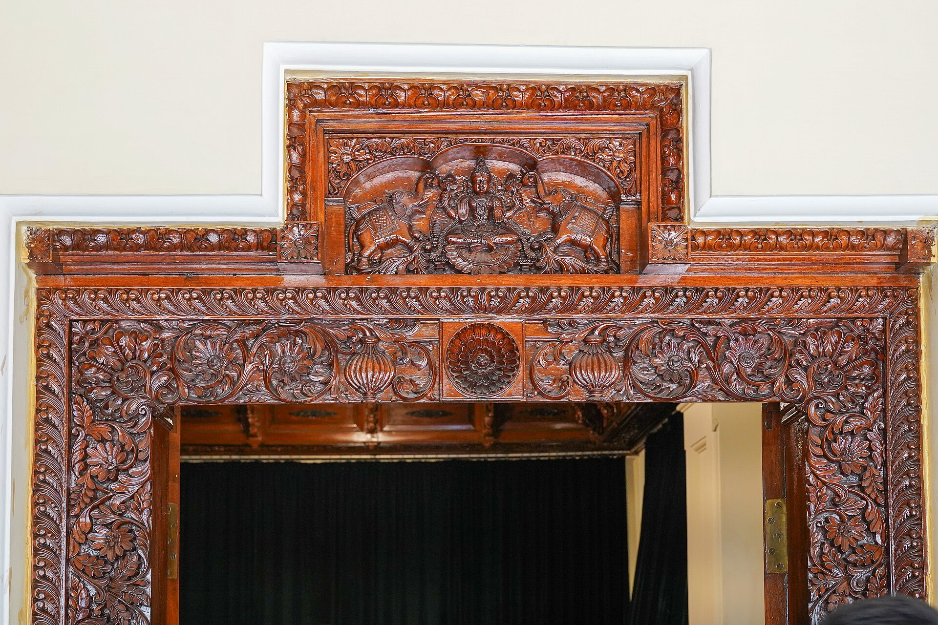 Mysore Palace Doorway | Indian Press An intricately carved wooden doorway at Mysore Palace showcases traditional Indian architecture and floral deity designs.