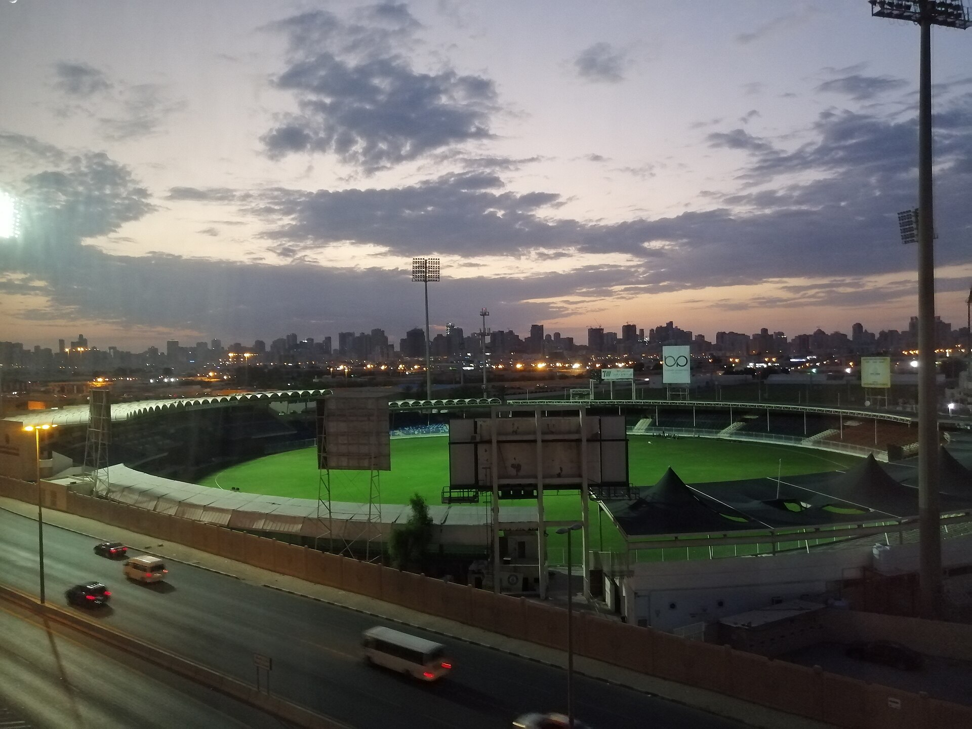 Sharjah Cricket Stadium | Indian Press A brightly lit Sharjah Cricket Stadium and city skyline at twilight, reflecting the passion for diaspora cricket.