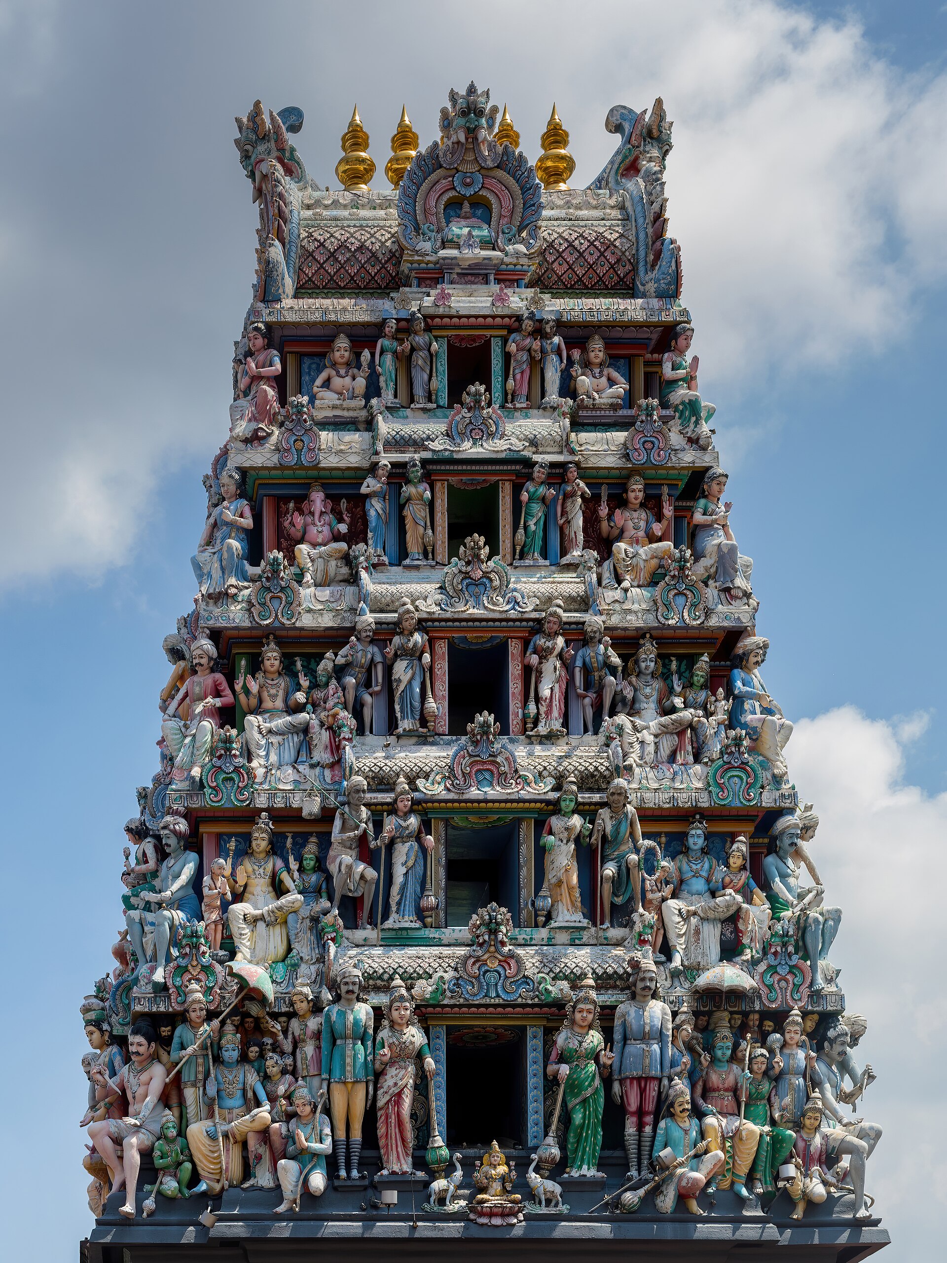 A colorful gopuram tower at Sri Mariamman Temple in Chinatown, Singapore showcases intricate Hindu deity sculptures.