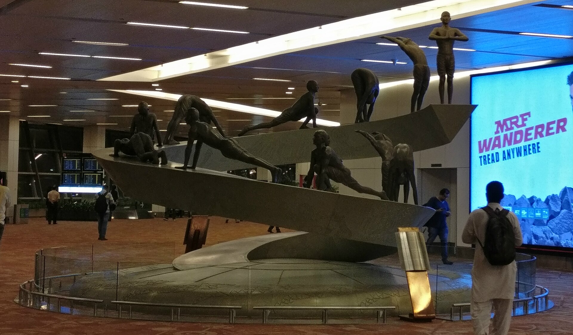 Skilled Migration | Indian Press A bronze sculpture of figures performing Surya Namaskara is displayed in the departure hall of Indira Gandhi International.