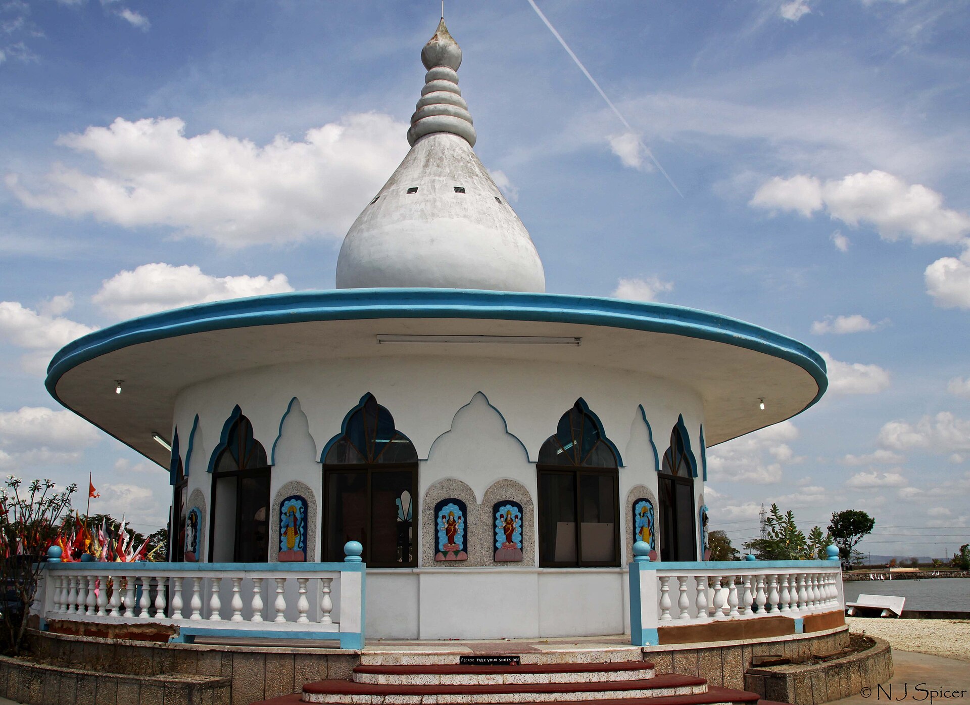 Waterloo Temple | Indian Press A white Buddhist temple in Trinidad stands against a cloudy sky, showcasing the Caribbean's Indian roots.