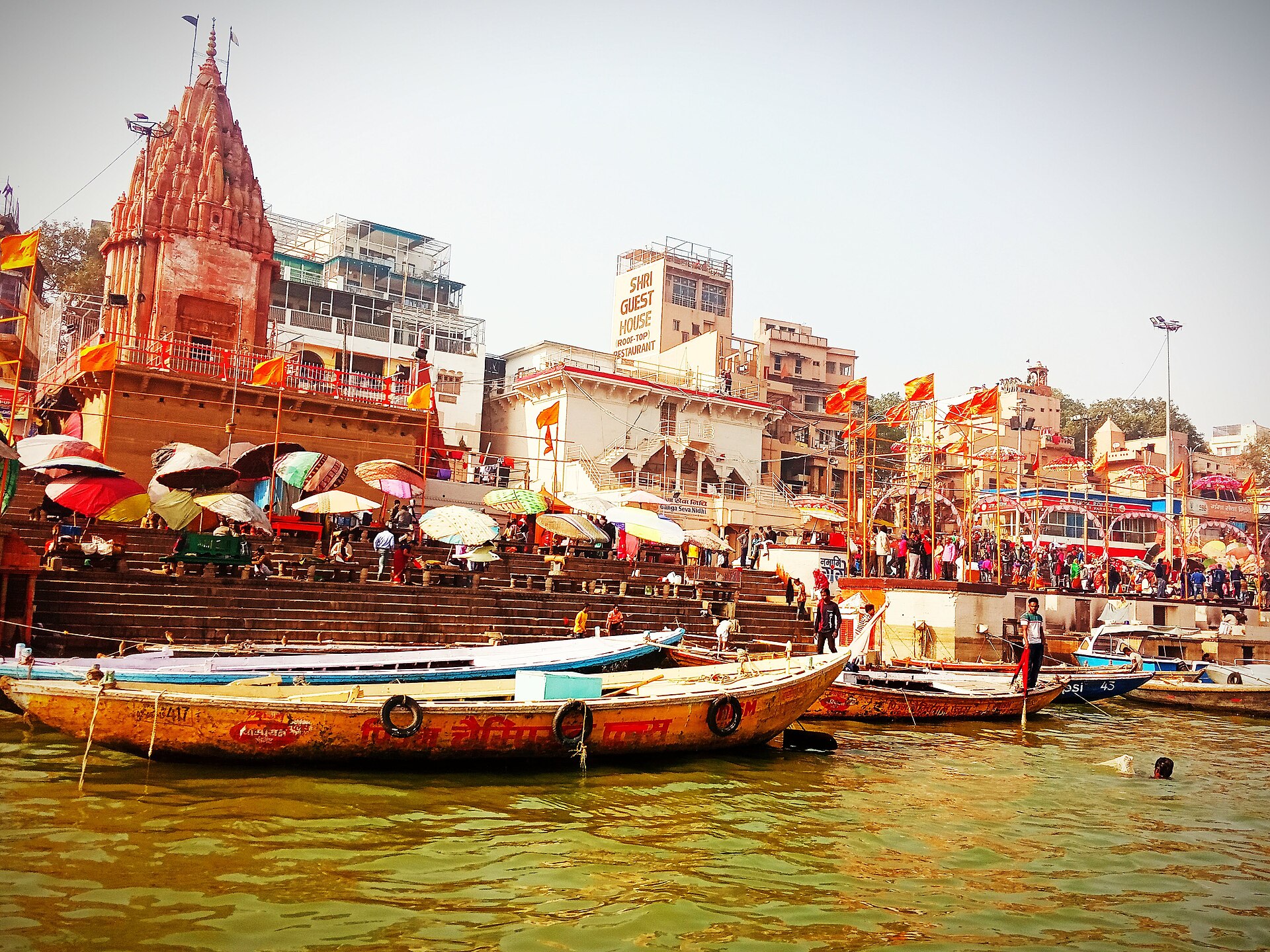 Boats float on the Ganges River near Varanasi's ghats and temples, showcasing India's rich cultural heritage.